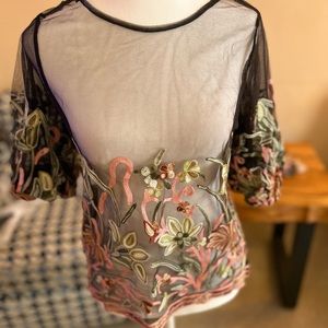 Gorgeous see-through top with flower detailing.